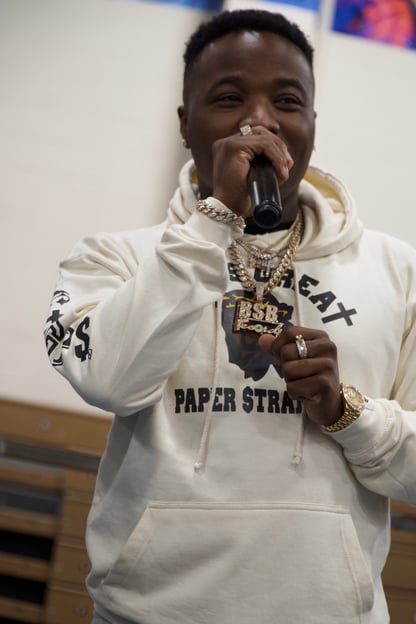 Troy Ave wearing a white GIGPS hoodie with a bold face Jesus logo in color with God Is Great Paper Straight classic lettering.